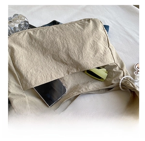 Detail shot of khaki canvas tote bag featuring a practical side pocket for smartphone