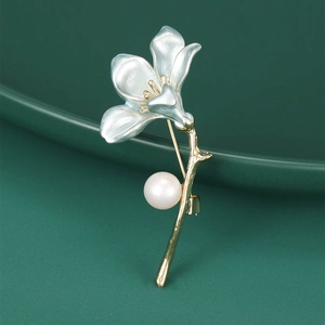 Detail of trumpet flower brooch with enamel petals, gold stem and a pearl accent