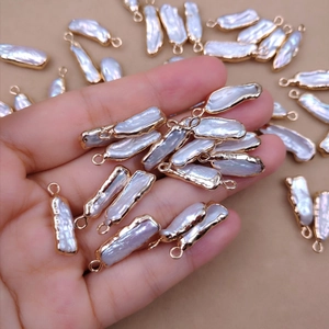 Baroque freshwater pearl pendants with gold plated edges held in palm for DIY jewelry