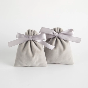 Graue Samt Schmuckbeutel mit Satinband Schleifen für elegante Geschenke und Aufbewahrung.