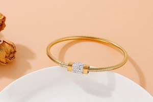 Détail d'un bracelet maille serpent doré avec curseur en cristal blanc sur plat