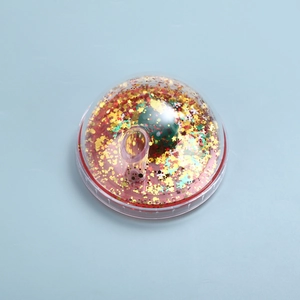 Detail of Christmas cup lid with red liquid, golden stars, and green ball ornament