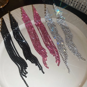 Detail of long tassel rhinestone earrings in black, rose pink, and silver finishes