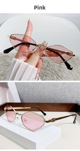 Detail of pink cat-eye sunglasses with golden metal frames and embossed temples