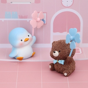 Detailed view of cute resin penguin and teddy bear figurines with windmills for car dashboard