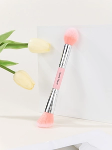 Macro detail of a dual-ended pink makeup brush for powder and highlighter application