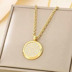 Close-up of golden round pendant necklace with micro-pave white cubic zirconia stones
