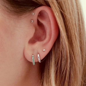 Detailed view of S925 silver ear cuff set with green emerald and zircon stones