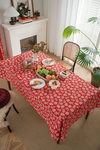 Detail of red cotton linen Christmas tablecloth featuring gingerbread man and snowflake prints