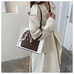 Detail of a chic leather tote bag with diamond texture and silk scarf decoration