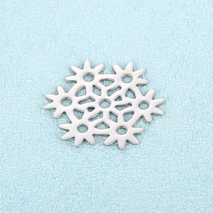 Silver snowflake metal pendant charm for DIY jewelry making on blue textured surface
