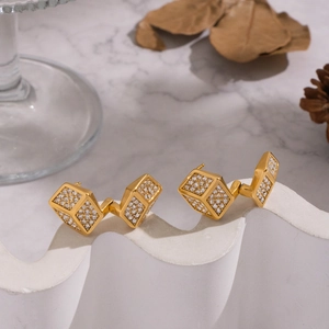 Luxe gold cube earrings with pave-set zircon crystals on white elegant display stand
