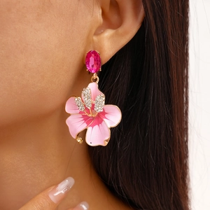 Dettaglio degli orecchini a fiore in smalto rosa con cristallo e strass brillanti