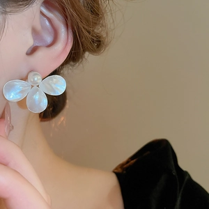 Elegant model shot of pearl flower stud earrings with white petals and gold detail