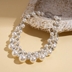 Vintage baroque faux pearl necklace with sparkling rhinestones on a textured tray