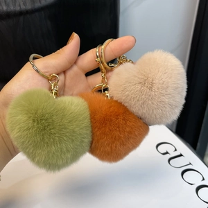 Fuffy heart-shaped plush keychains in green, orange, and brown with gold hardware