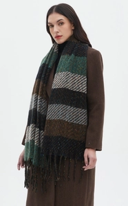 Close-up detail of heavy knit striped scarf with decorative fringe tassels and plaid pattern