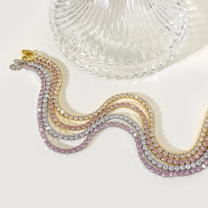 Detail of gold and silver tennis bracelets with sparkling white and pink stones