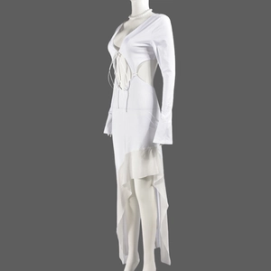Détail de robe blanche à manches longues avec laçage à la poitrine et ourlet en tulle