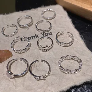S925 sterling silver ring set featuring heart, bow, and dog charms on a beige background
