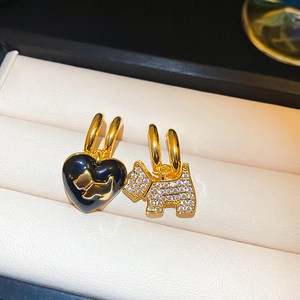 Asymmetric gold puppy heart earrings with zircon stones in a beige jewelry gift box