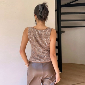 Détail d'un débardeur ajusté à paillettes or café avec dos croisé sur mannequin