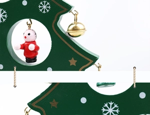 Detail of wooden Christmas tree decor with red hanging figures and golden bells