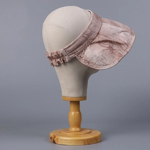 Close-up of pink bow visor hat with leaf pattern and elastic band for sun protection