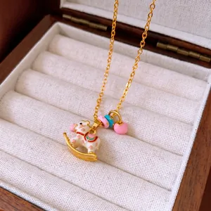 Cartoon carousel necklace with golden chain and white enamel horse pendant in a gift box