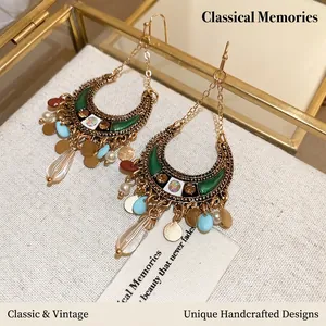 Bohemian gold moon tassel earrings with colorful beads and sequins on a fabric display
