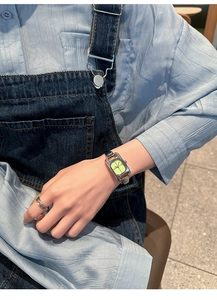 Close-up of elegant square silver watch with neon green dial on a woman's wrist