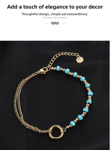 Detail of vintage turquoise beaded gold chain bracelet with polished metal ring and tag