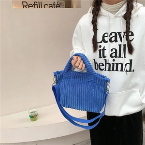 Détail de la texture du sac en velours côtelé bleu roi et des boucles métalliques