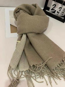 Detailed close-up of beige color-block cashmere-feel scarf with twisted tassel fringe