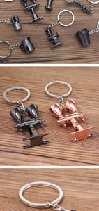 Close-up of coffee tool keychains in black and rose gold finish on a wooden background