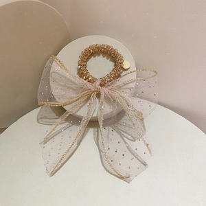 Dettaglio elastico per capelli in tulle champagne con fiocco di paillettes e perle