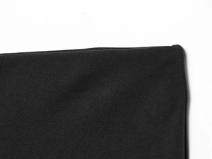 Close-up of the black knit fabric texture and hemline stitching on the elegant skirt