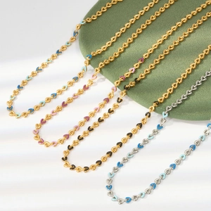 Detail of colorful enamel heart pendants on gold and silver titanium steel chains