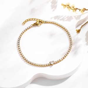 Détail d'un bracelet de tennis doré orné d'un pendentif scintillant en zircon en forme de cœur