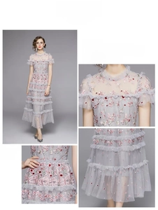 Detail von Blumenstickerei und Mesh-Rüschen an einem hellgrauen Abendkleid