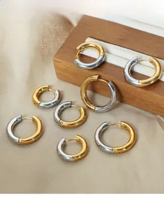 Detailed macro view of two-tone gold and silver hoop earrings on elegant silk background