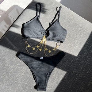 Detail of black ribbed bikini featuring decorative gold metal chains and sequins