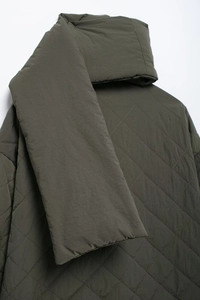 Detail shot of olive green diamond-quilted jacket fabric with matching scarf collar