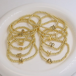 Golden 18k brass beaded elastic bracelets set featuring twelve zodiac sign charms