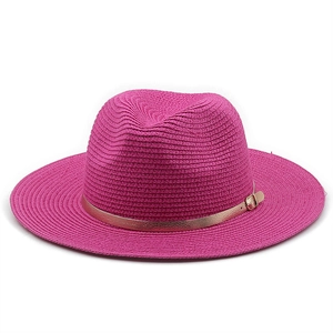 Detail of fuchsia woven straw hat with golden metal band buckle on white background