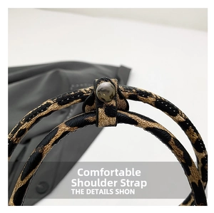 Detailed close-up of the leopard print strap and black leather buckle on the stylish handbag