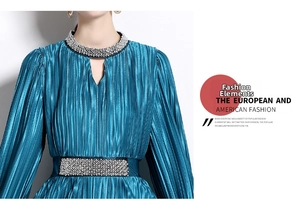 Detail of teal pleated dress featuring exquisite rhinestone neckline and sequined waist