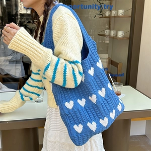 Detail of blue knitted tote bag with white heart jacquard and braided texture
