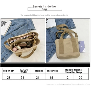 Detail view of small canvas tote capacity showing smartphone, keys, and lipsticks inside