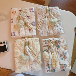Detailed close-up of quilted floral fabric pouches with decorative pearl charms